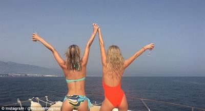 Nicola grabbed hold of a friend while the two raised each other's hands up in the air, flaunting their sexy figures in the process and relishing the breath-taking view of the sea.