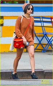 Zoe Kravitz walking in shorts and an orange top
