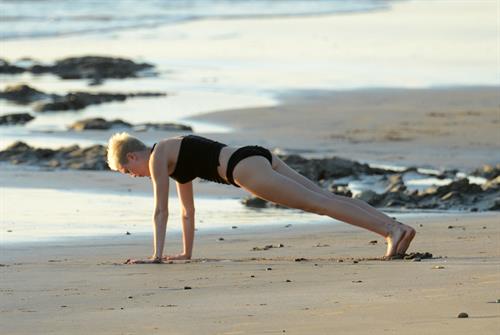 Miley Cyrus  yoga in black bikini on beach in Hawaii 1/24/13 