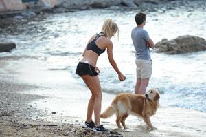 Kimberley Garner in a black bikini on the beach in St. Tropez on July 31, 2014