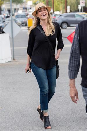 Julie Benz walking in jeans and a hat