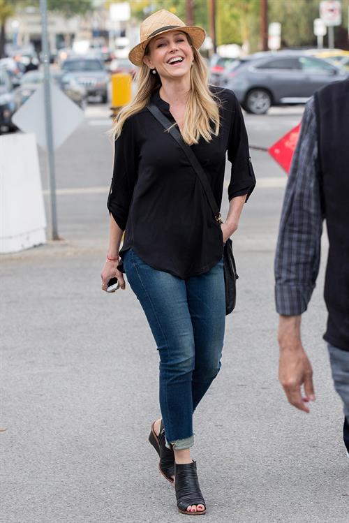 Julie Benz walking in jeans and a hat