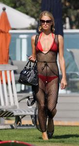Paris Hilton at the beach in a skimpy red bikini and fishnet kaftan in Malibu.July 12, 2013
