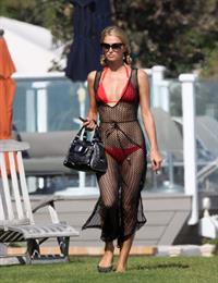 Paris Hilton at the beach in a skimpy red bikini and fishnet kaftan in Malibu.July 12, 2013