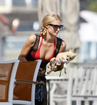 Paris Hilton at the beach in a skimpy red bikini and fishnet kaftan in Malibu.July 12, 2013