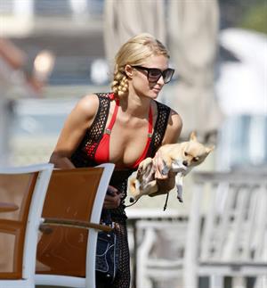 Paris Hilton at the beach in a skimpy red bikini and fishnet kaftan in Malibu.July 12, 2013