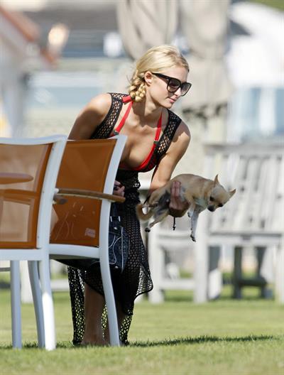 Paris Hilton at the beach in a skimpy red bikini and fishnet kaftan in Malibu.July 12, 2013
