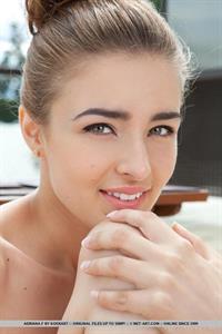Adriana F nude outside with a green and white chair
