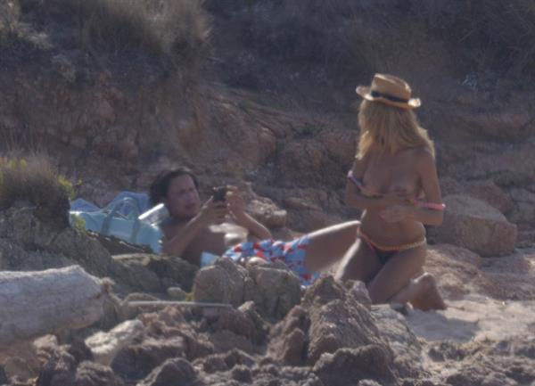 Heidi Klum topless sunbathing