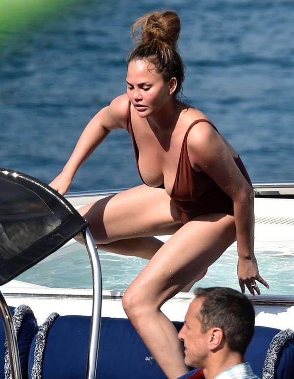 Chrissy Teigen sexy cleavage and ass in a swimsuit with her husband John Legend seen by paparazzi.
