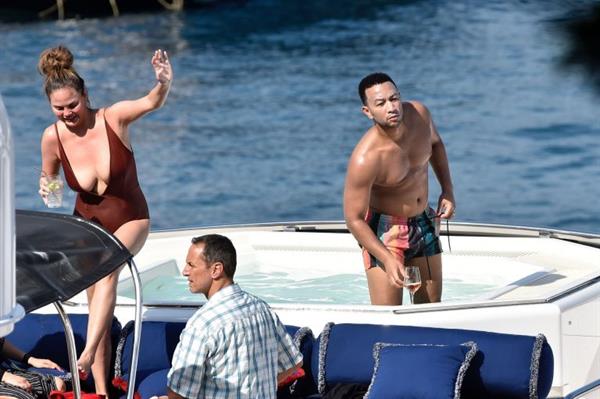 Chrissy Teigen sexy cleavage and ass in a swimsuit with her husband John Legend seen by paparazzi.
