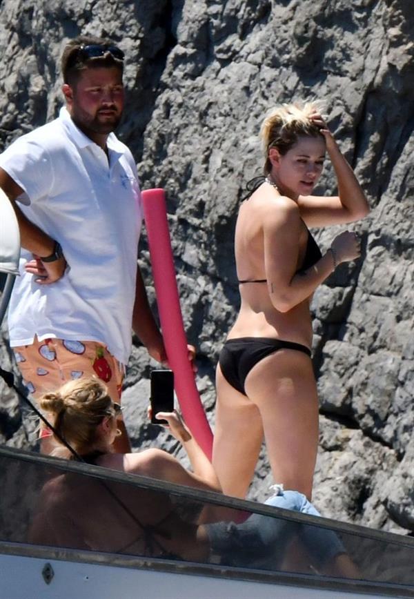 Kristen Stewart nude boobs caught topless by paparazzi tanning on a boat.
