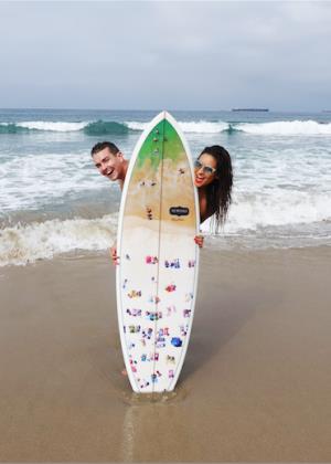 Shay Mitchell at the beach with a surfboard