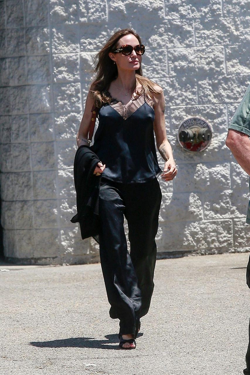 Angelina Jolie Pictures Angelina Jolie braless tits pokies in a black top seen by paparazzi showing her hard nipples.