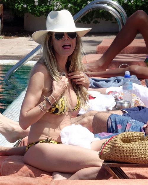 Heidi Klum Pictures Heidi Klum nip slip in a sexy bikini seen by paparazzi and kissing her husband and flashing her boob.
