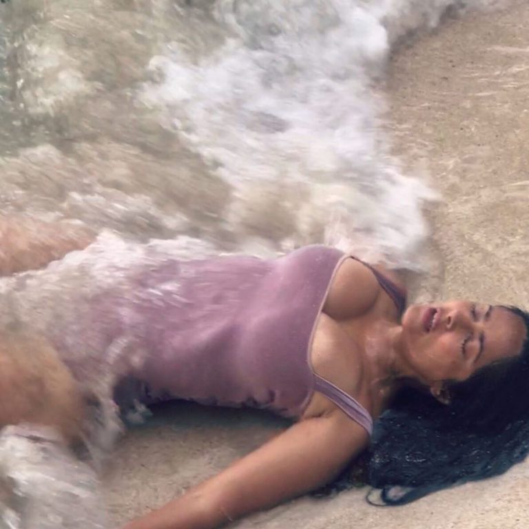 Salma Hayek Pictures Salma Hayek big boobs showing nice cleavage wet in a swimsuit laying on the beach.