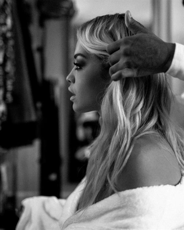 Rita Ora nude in just a robe backstage showing some nice cleavage.


