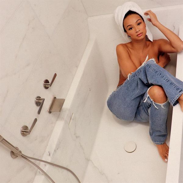 Draya Michele topless sitting in her bathtub in just jeans covering her nude boobs.










