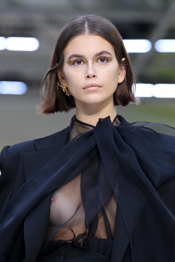 Kaia Gerber nip slip caught with her braless boobs in a see through top modelling on the runway.































