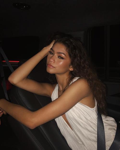 Zendaya Coleman Pictures Zendaya braless in a low cut dress in the car looking sexy.