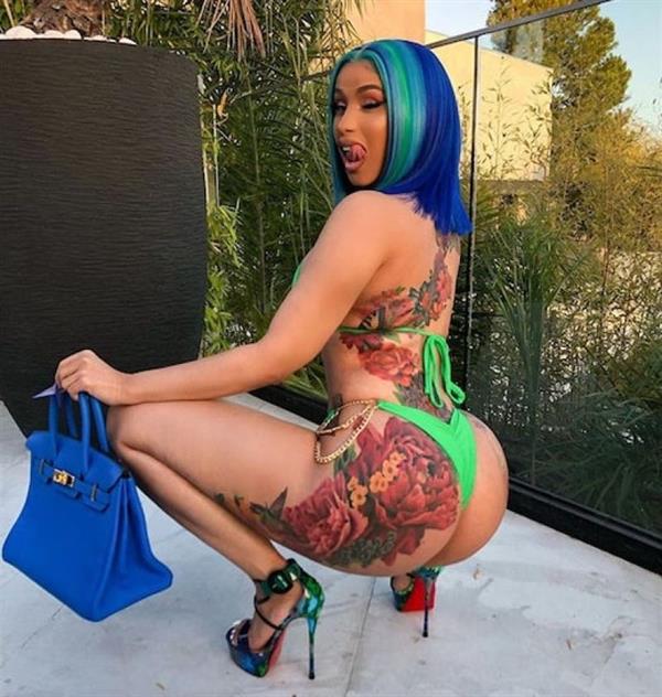 Cardi B showcasing her just finished huge back tattoo that took months to complete and goes down her back below her sexy ass booty as she shows it off in a thong bikini.