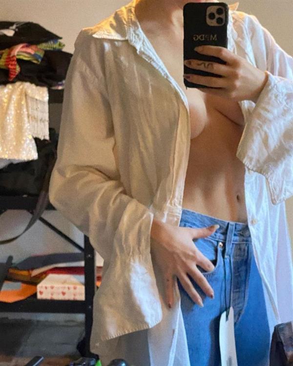 Dove Cameron braless boobs in an open top showing off her tits and cleavage with her hot model body wearing just jeans.