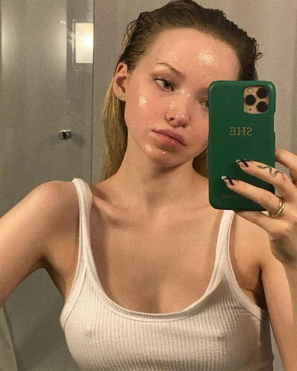 Dove Cameron braless boobs in a white tank top showing off her tits pokies in three new selfies in her bathroom.
