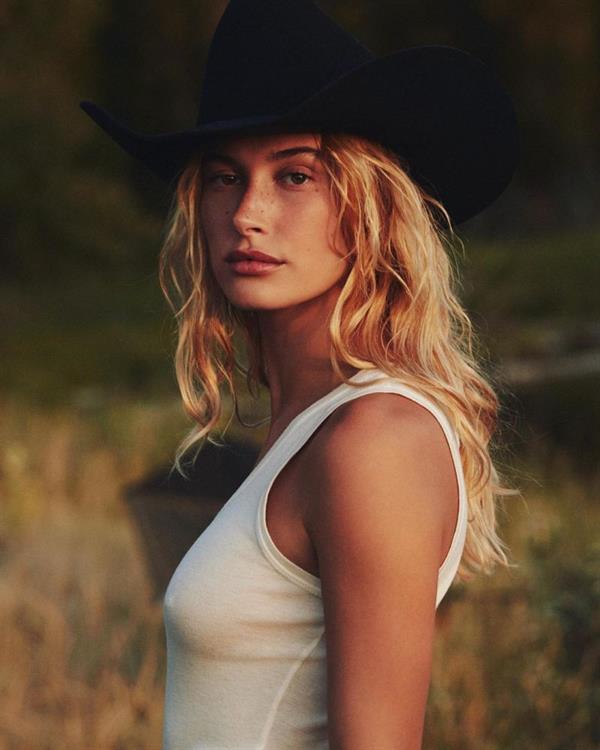 Hailey Baldwin Bieber braless boobs in a white tank top showing off her tits pokies during a new photoshoot also wearing a cowboy hat.