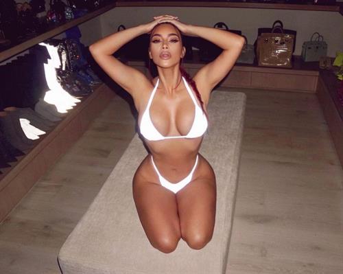 Kim Kardashian boobs showing nice cleavage with her big tits in a sexy white thong bikini on her knees in her closet.