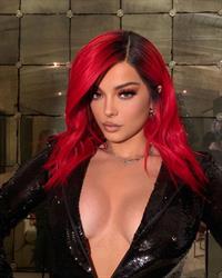 Bebe Rexha braless boobs showing nice cleavage with her tits in a sexy low cut black outfit.