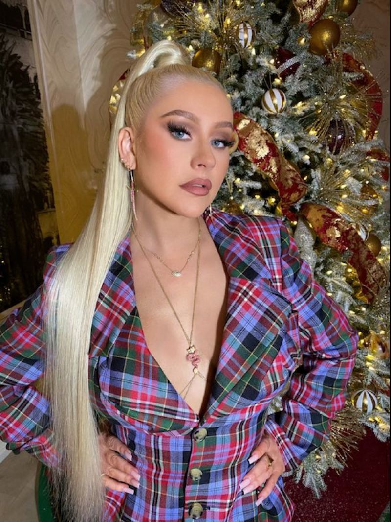 Christina Aguilera Pictures Christina Aguilera braless boobs showing nice cleavage with her big tits in a low cut sexy pantsuit.