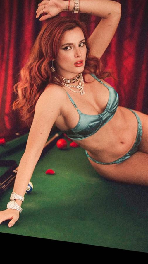 Bella Thorne boobs showing nice cleavage with her big tits in sexy green lingerie posing on a pool table with matching bra and panties.