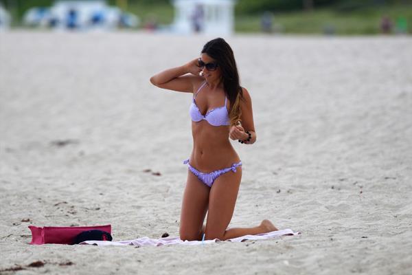 Claudia Romani in a purple thong bikini at the beach