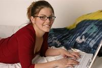 Sara Sexton on the bed with her laptop